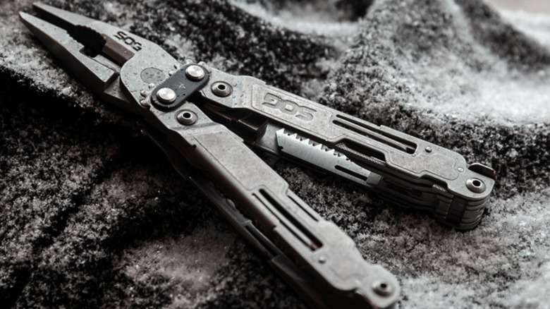 SOG Knives multi-tool open on snowy blanket