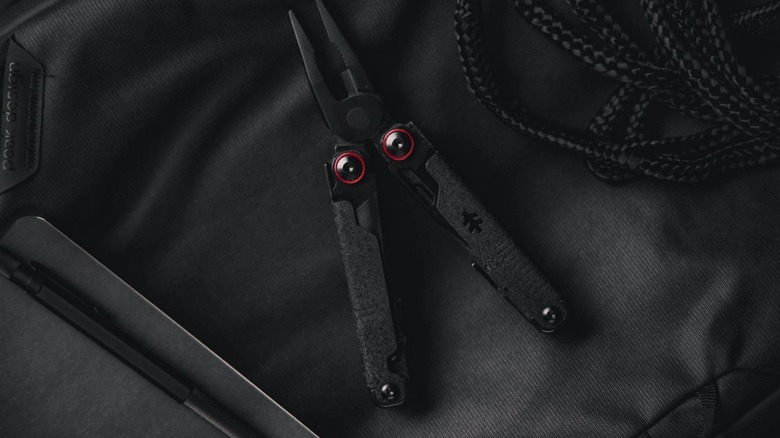 Swiss Tech Praktisch multi-tool on black fabric