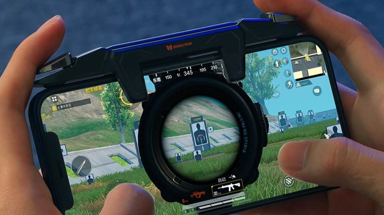 Clip-on mobile gaming triggers installed on a smartphone.