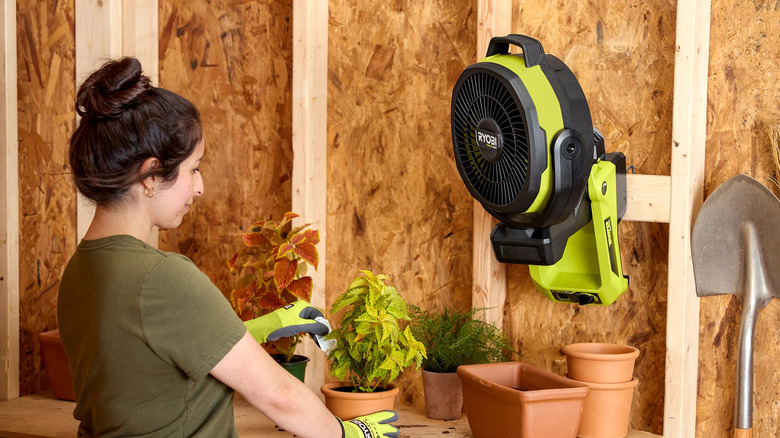 Ryobi 18V One+ HP Hybrid 9 inch oscillating fan mounted to a shed wall