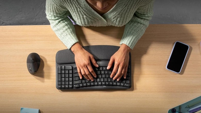 Person typing on a Logitech ergonomic keyboard