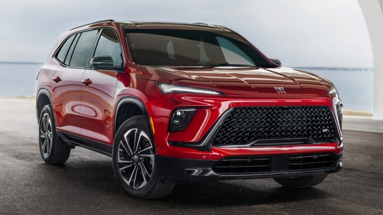 Red Buick Enclave parked with body of water in the background