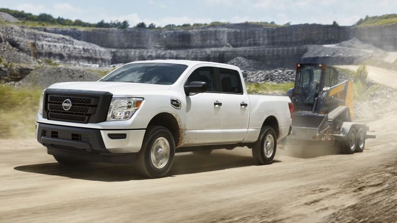 An action shot of a white 2024 Nissan Titan towing