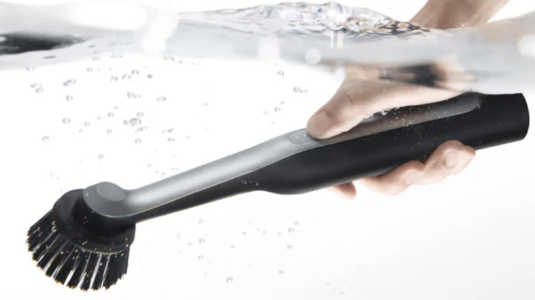 Hand holding the HOTO Scrub Spinner under water.