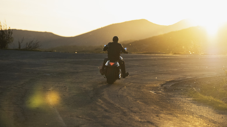 Rider driving away into the sunset