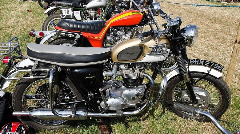 1964 triumph bonneville t120 motorcycle next to other vintage bikes
