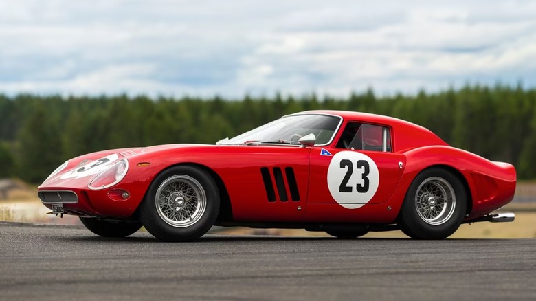 a red Ferrari 250 GTO parked on pavement