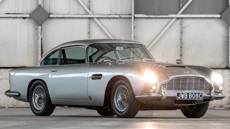 an Aston Martin DB5 parked in an empty hangar