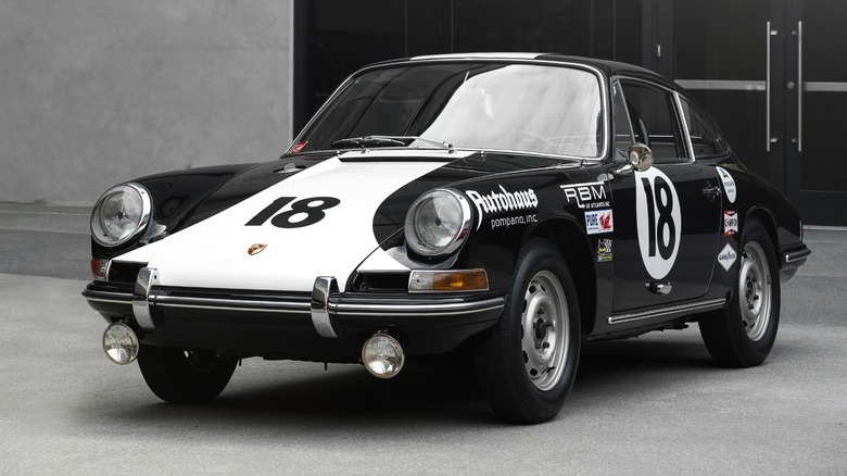 a 1964 Porsche 911 in front of a building