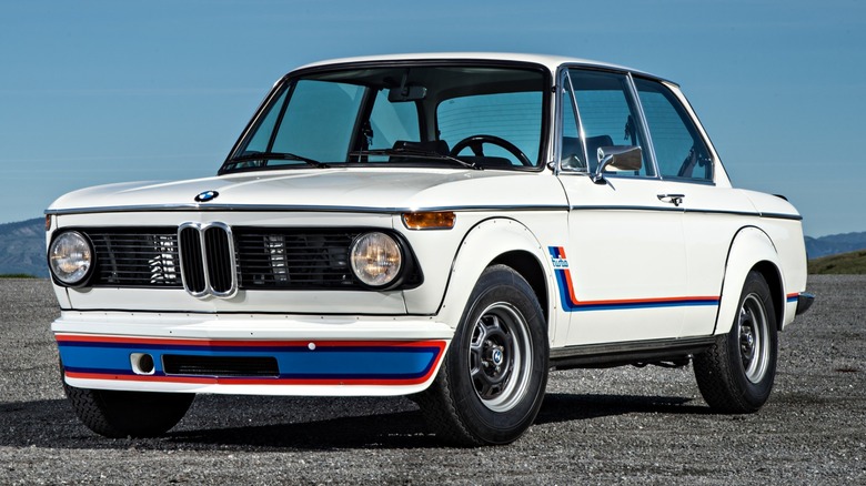 a white BMW 2002 turbo on a gravel surface