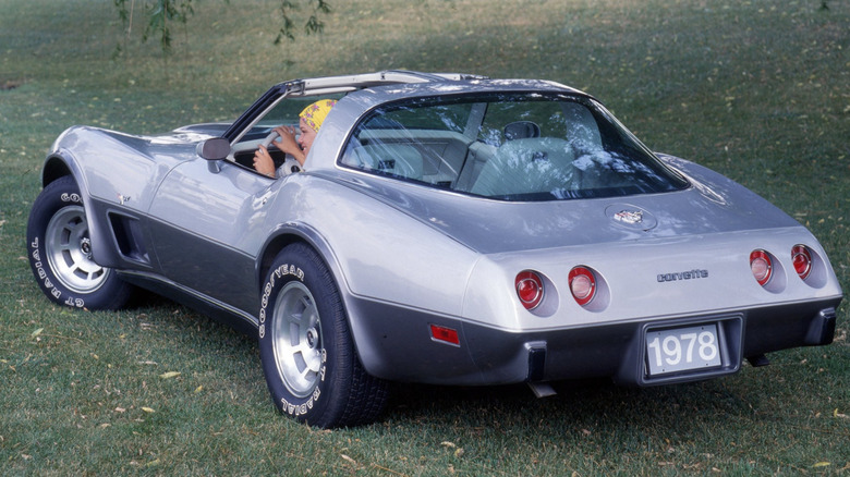 A 1968 silver Chevrolet Corvette Stingray coupet in a grass field.