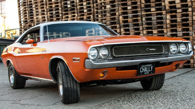 a 1970 Dodge Challenger parked in front of some pallets
