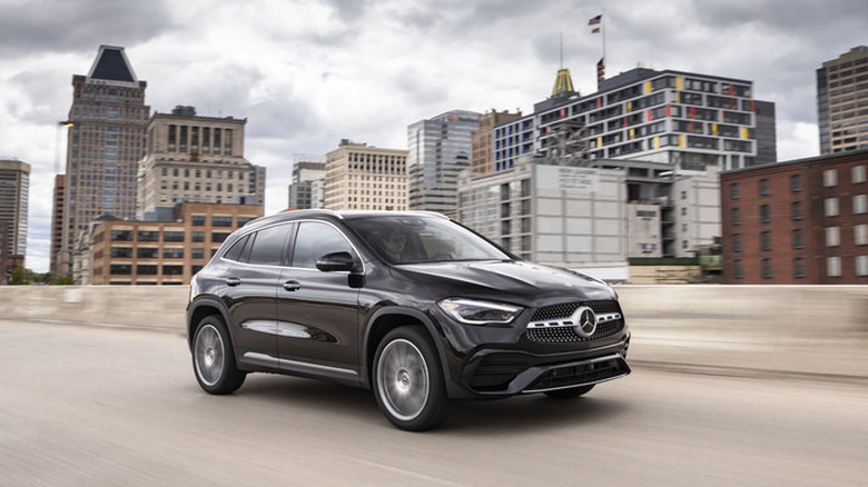 A black 2020 Mercedes-Benz GLA on a city road under cloudy skies.
