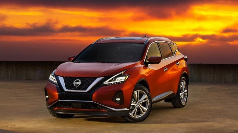 A red-orange 2020 Nissan Murano parked outdoors at sunset.