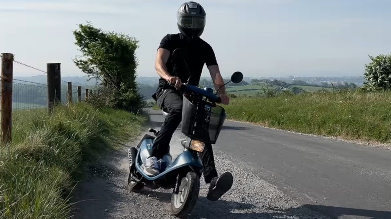 Guy riding a Honda Zook onto shoulder