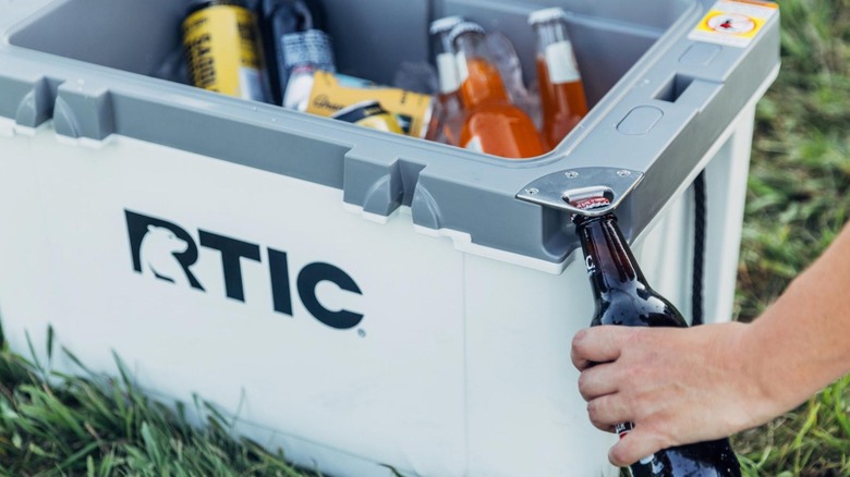 Person opening bottle with RTIC 32-Quart Cooler