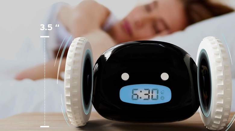 Someone sleeping near a Clocky alarm clock.