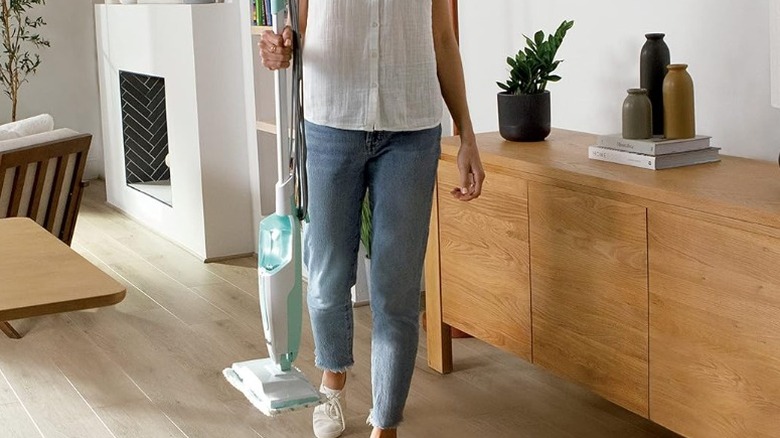 Person holding a Shark S1000 steam mop in a living room