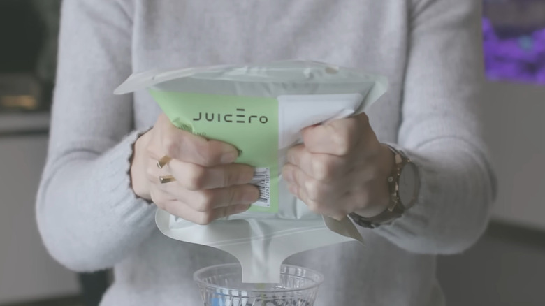 Bloomberg Reporter squeezes a Juicero pack into a cup