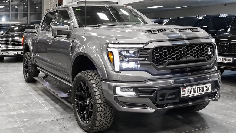 A heavily modified Shelby F-150 in satin grey sitted inside a truck dealership.