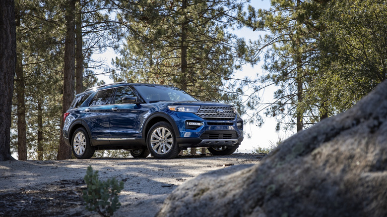 A blue 2020 Ford Explorer standing at an angle on a frosty, forested road.