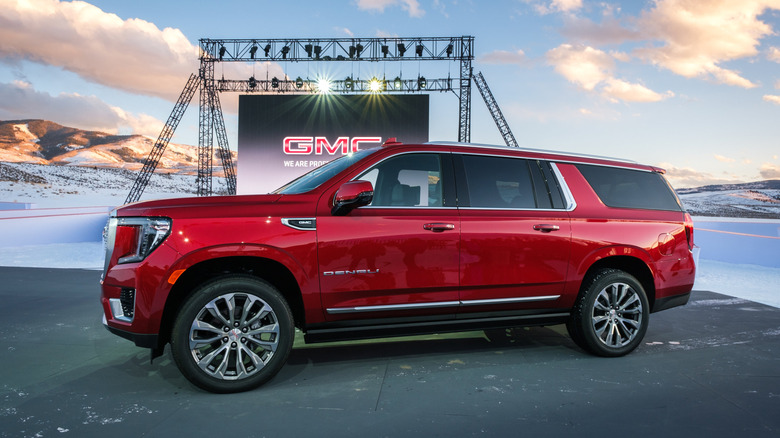 A cherry red Yukon XL from 2021 at a launch event in a snowy area of Colorado.