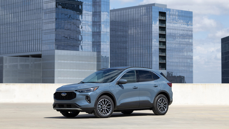 A vapor colored 2023 Ford Escape parked in an open space with buildings in the back.