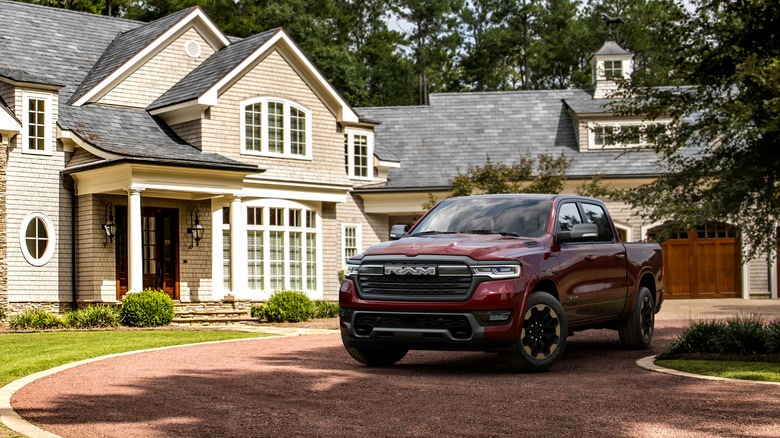 A red 2025 RAM 1500 Laramie parked on a suburban driveway.