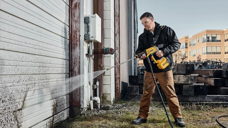 Man cleaning building with DeWalt Water Power Cleaner