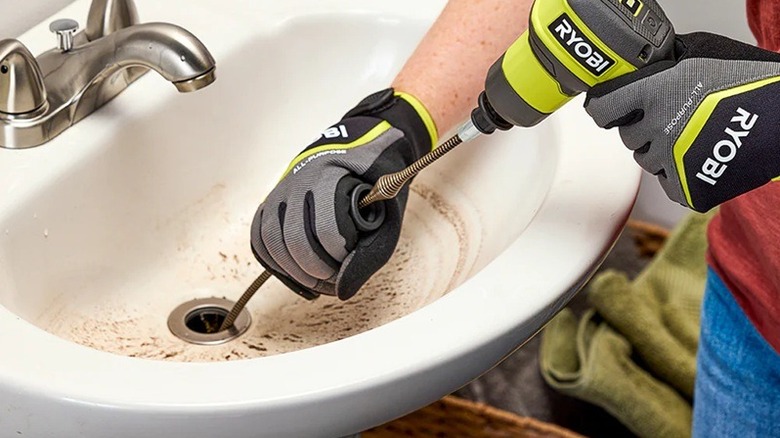 Person using Ryobi drain auger