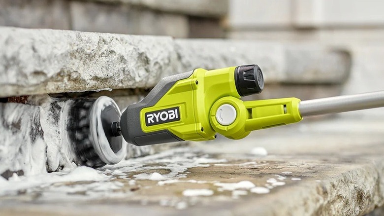 Person using telescoping power scrubber