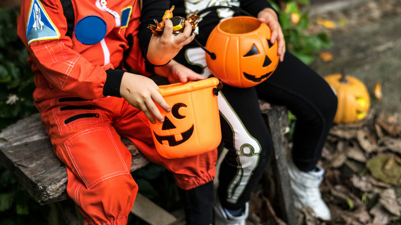 Children with orange candy containers