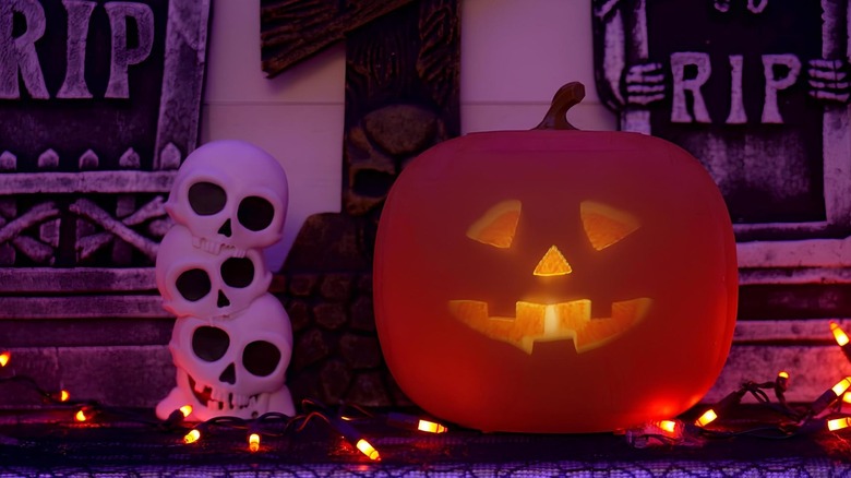 Animated pumpkin on top of a table next to three skulls