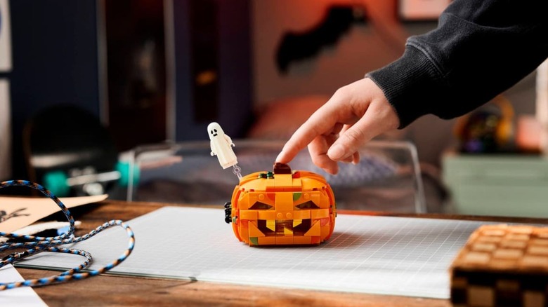 Man pressing on lego halloween pumpkin