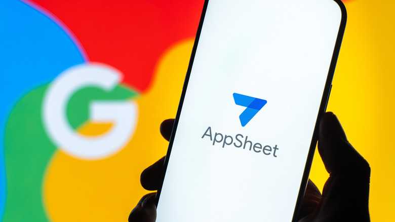 An AppSheet logo on a phone with a Google "G" in the background.