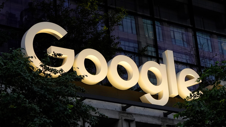 A Google logo on a building lit up at night.