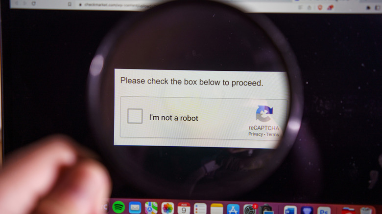 A reCAPTCHA prompt on a computer as seen from a magnifying glass.