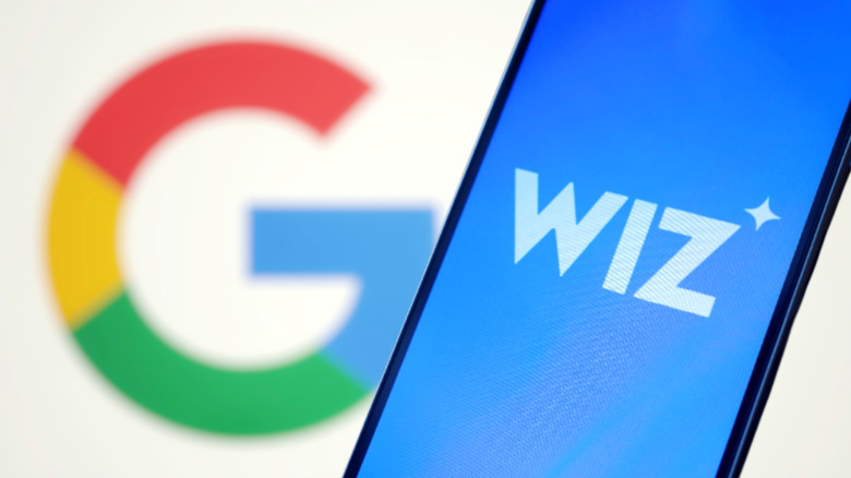 A smartphone showing the Wiz logo with a Google "G" in the background.