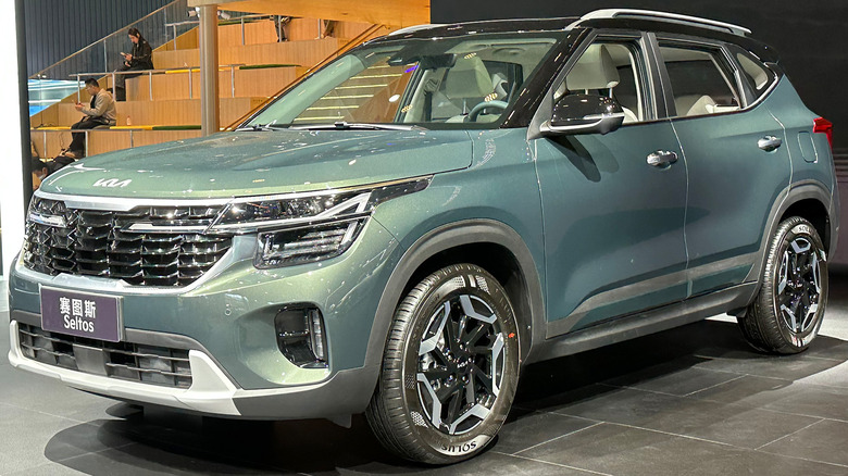 A green Kia Seltos on a showroom floor