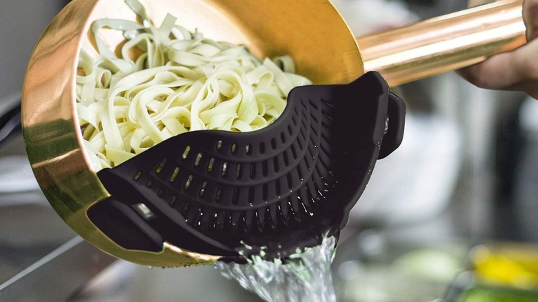 Person using pasta strainer