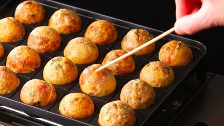 The Takoyaki Super Entako Flame Octopus Portable Oven filled with octopus balls