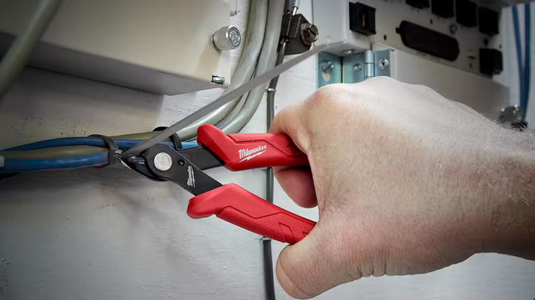 A worker trimming a cable tie with Milwaukee's mini flush cutting pliers