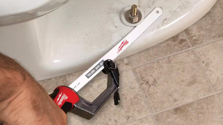 DIYer using the Milwaukee compact hack saw on a toilet fitting