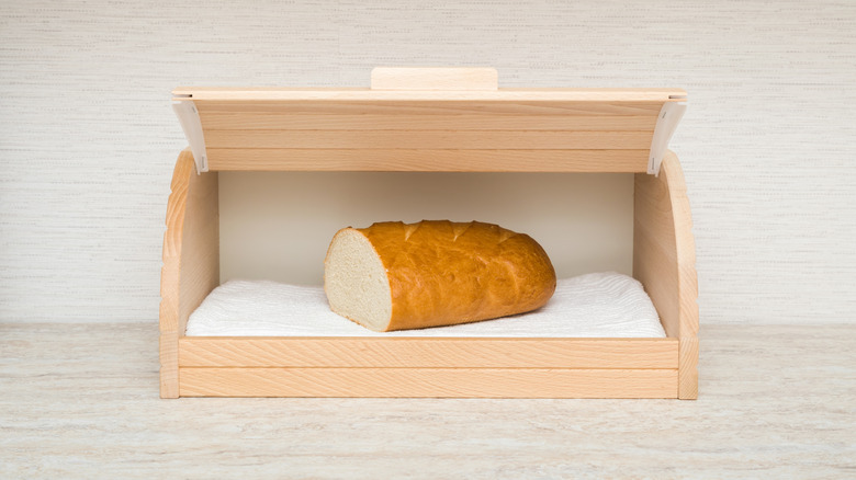 Old-school bread box open to show a sliced loaf.