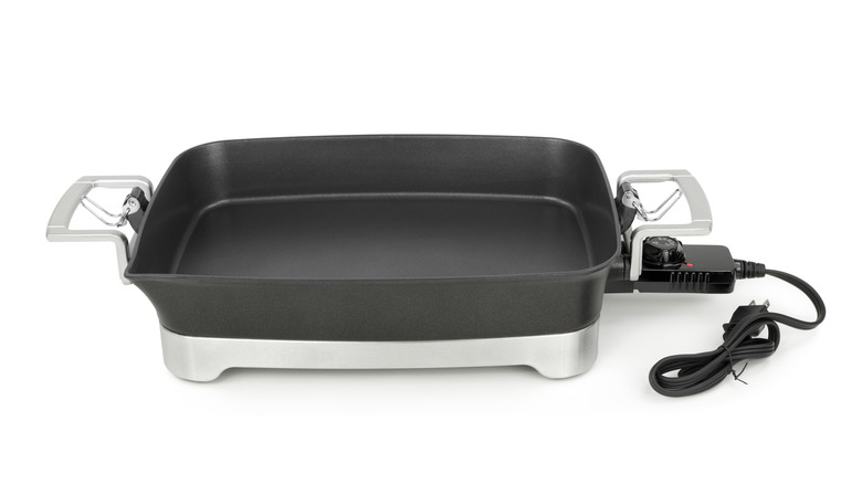 Stock photo of an electric skillet with power cord.
