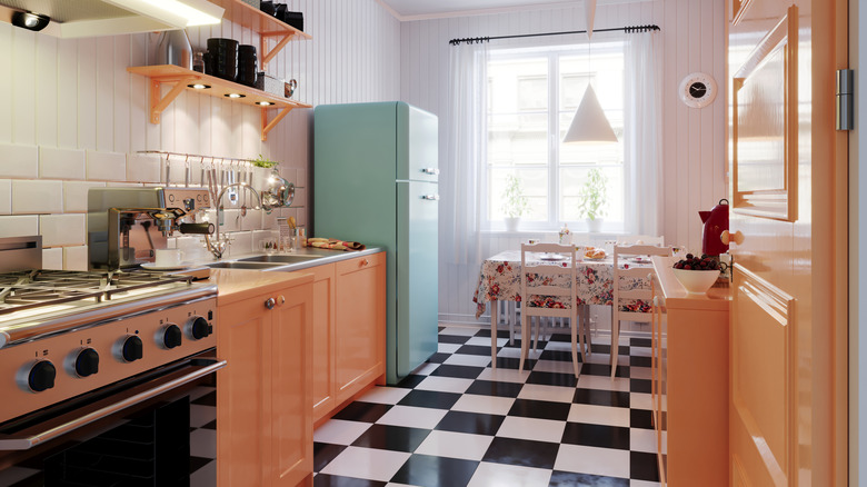 Vintage kitchen with black and white checker floor and old appliances.