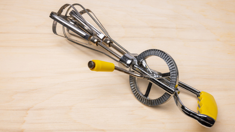 Stock photo of a manual egg beater on a table.