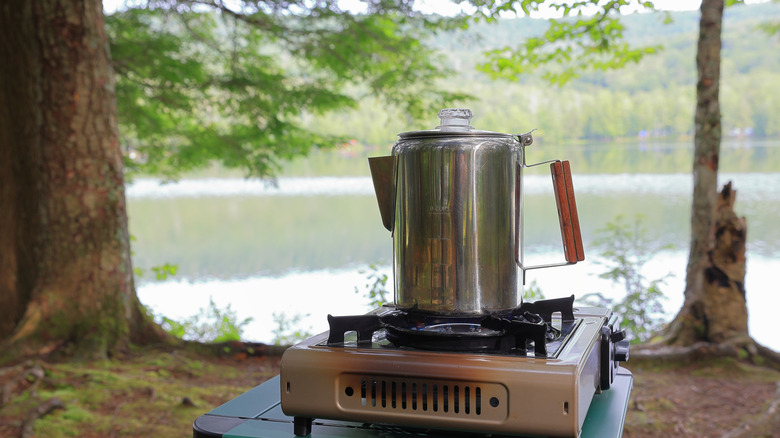 Coffee percolator on an outdoor campsite cooktop.