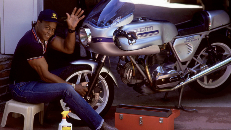 Actor Roger E Moseley cleans his Ducati SuperSport 900 in his garage.