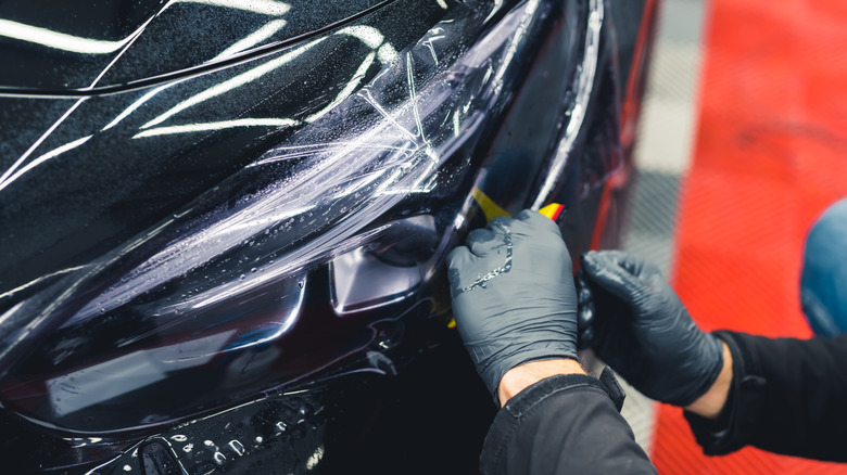 Tint wrapping being applied to a car headlight